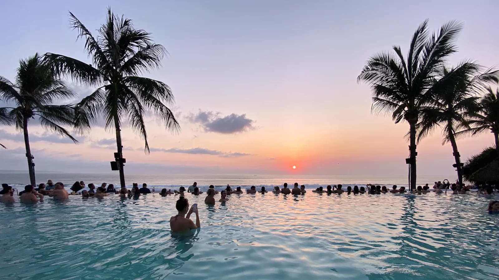 Poolside coconut palms facing the ocean at a Seminyak Beach resort in Bali
